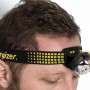 Energizer Vision Ultra Kopflampe mit gelb-schwarzem Stirnband am Kopf befestigt.