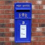 Blauer Monstershop Briefkasten im schottischen Stil an einer Backsteinwand.