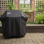 Abgedeckter Weber Gasgrill E-310 Spirit 2025 Schwarz mit Schutzhülle im Garten.