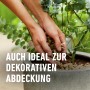 Hände verteilen COMPO Granuplant Drainage- und Pflanzgranulat im Topf als Dekoration und Drainageschicht.