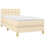 Cremefarbenes Boxspringbett 90x190 cm mit Matratze und Stoffbezug.