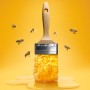 Schöner Wohnen Trendfarbe Honey Farbtester mit Pinsel und Honig-Motiv.