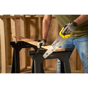 Stanley Jetcut Handsäge beim Sägen von Holz auf einer Werkbank. Feine Säge mit gelbem Griff.