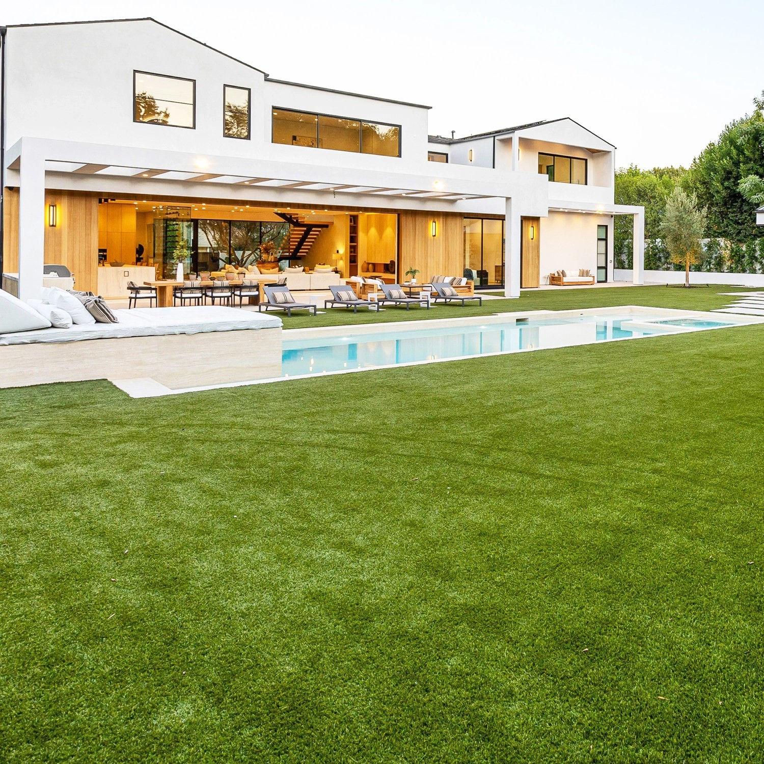 Sattgrüner Primaflor Kunstrasen Milo im Garten mit Pool und modernem Haus.