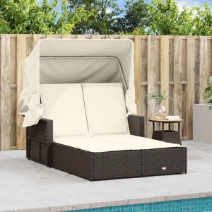 Braune Doppel-Sonnenliege aus Rattan mit Dach und cremeweißen Auflagen für den Garten.