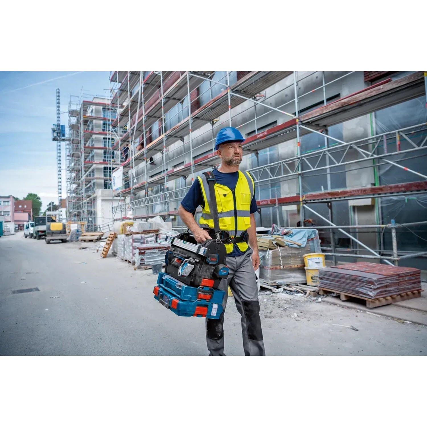 Bosch Professional Werkzeugtasche GWT 20 mit Handwerker auf Baustelle.