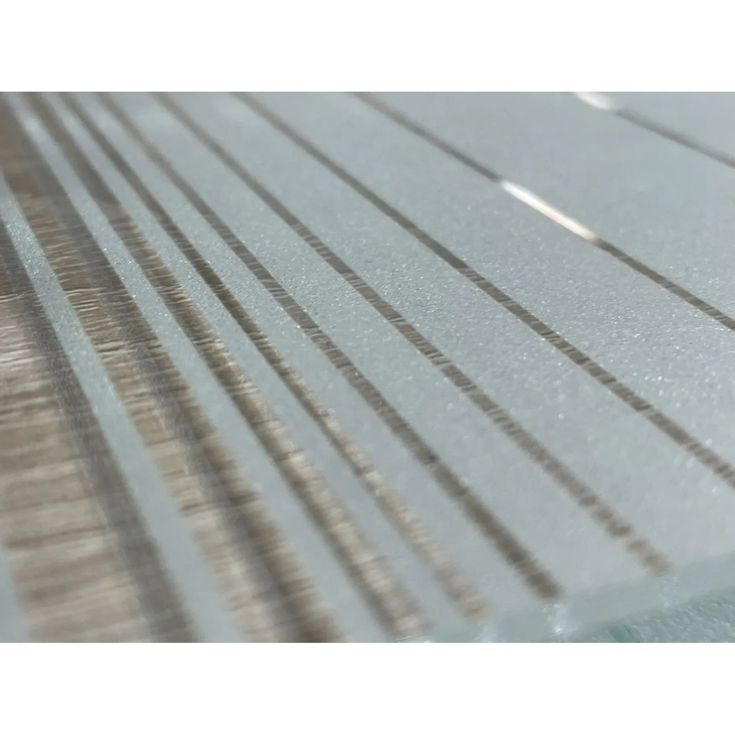 Detailaufnahme: Lasermattierte Glasschiebetür mit Streifenmuster für den Innenbereich.