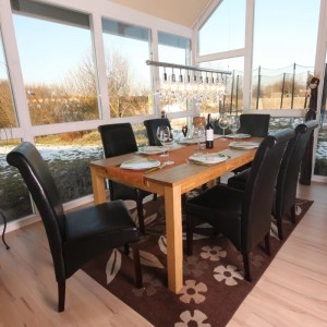 Esstisch mit 6 schwarzen MCW Lederstühlen. Dunkle Holzfüße, gedeckter Tisch.