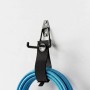 Schwarzer Wandhaken aus Edelstahl mit Organizer-Band hält blauen Schlauch an weißer Wand. Ideal für Garage & Werkstatt.