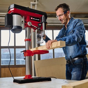 Einhell Säulenbohrmaschine TC-BD 630/1 beim Bohren von Holz. Tischbohrmaschine in Rot und Silber.