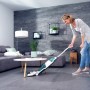 Frau nutzt Leifheit Akku-Saugwischer Regulus Aqua PowerVac zur Bodenreinigung im Wohnzimmer.