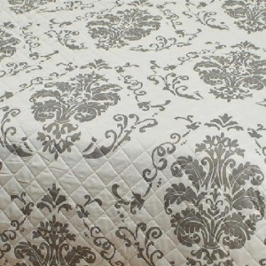 Bestlivings Tagesdecke Floria mit grauem Blumenmuster und Steppung.