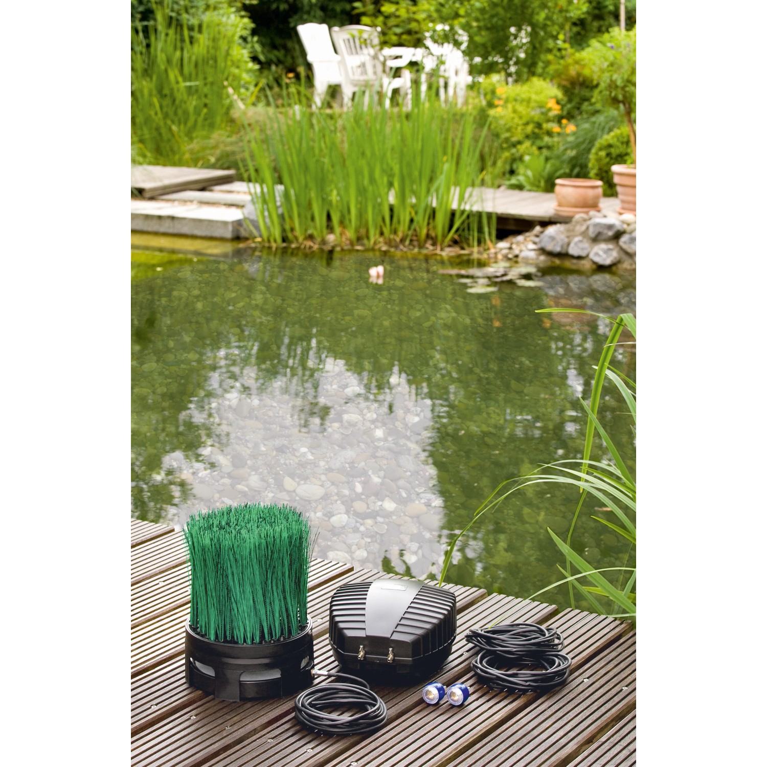 Oase OxyTex Set 1000 Teichbelüfter mit Filtermedium und Zubehör vor Gartenteich.