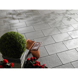 Verlegte Kann Terrassenplatten Sincera Grau 60x40 cm mit Pflanze und Stuhl auf der Terrasse.