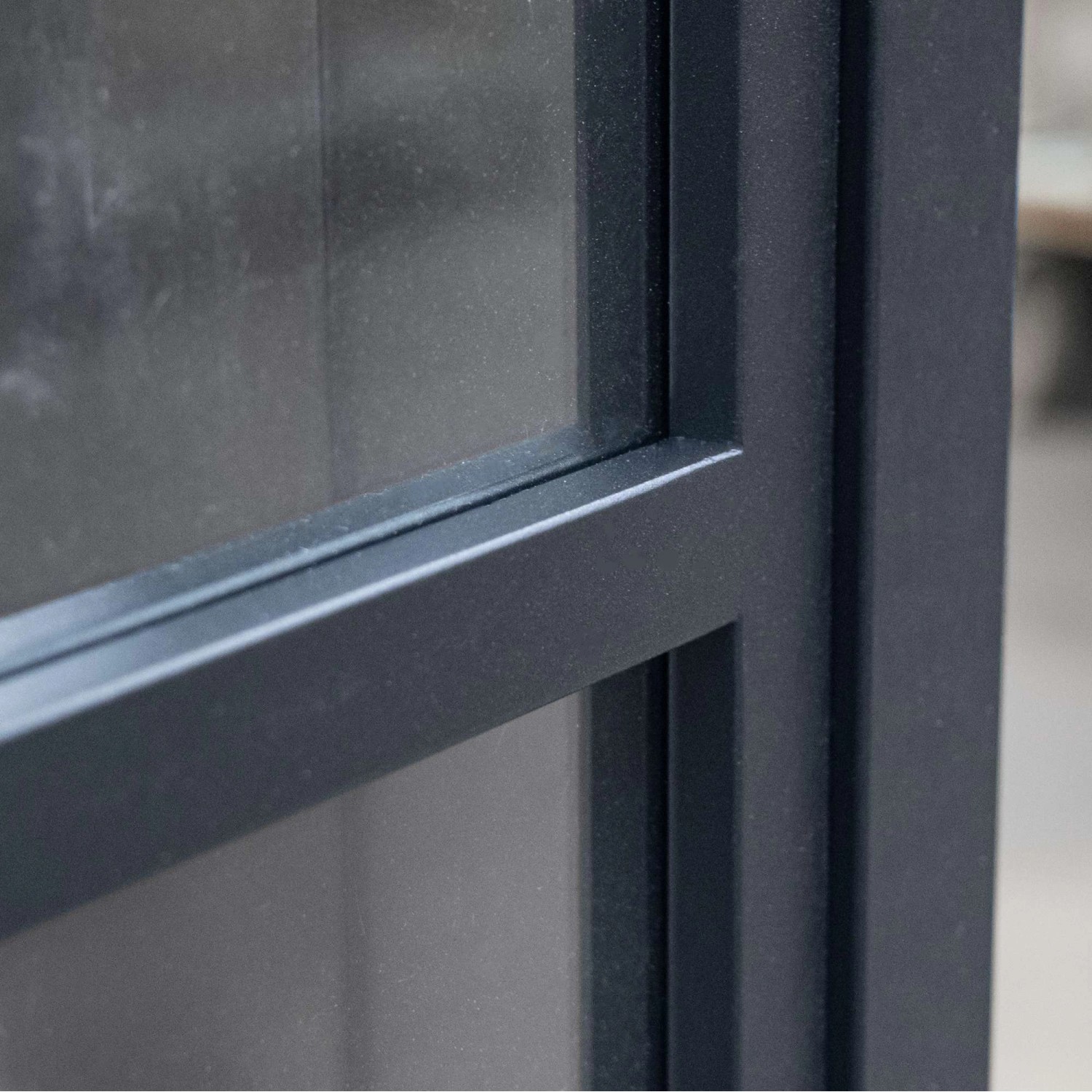 Detailaufnahme: Schwarze inova Loft Glasschiebetür mit 3 Feldern und Stahlrahmen.