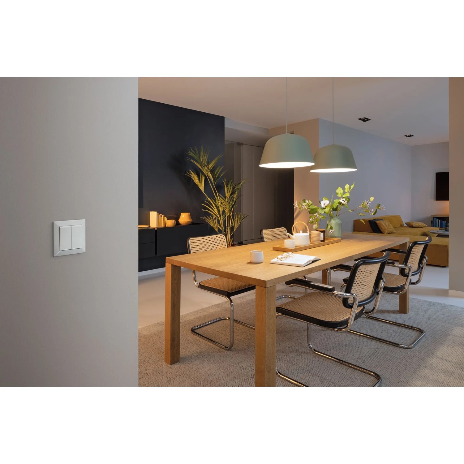 Weißer Doppel-Schalter der Bosch Smart Home Licht-/Rollladensteuerung an grauer Wand im modernen Essbereich.