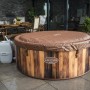 Runder LAY-Z-SPA Helsinki AirJet Whirlpool mit Abdeckung und Pumpe in Holzoptik.