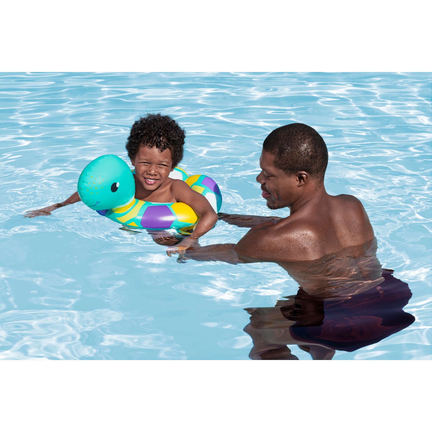 Kind mit Bestway Schwimmring (Motiv Schlange) im Pool, betreut von einem Erwachsenen.