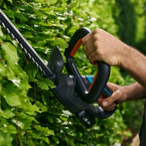 Gardena Akku-Heckenschere EasyCut 45/18V in Aktion, schneidet Hecke. Ergonomischer Griff, kabellose Freiheit.