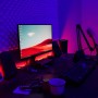 Schreibtisch mit Brilo Wifi-LED-Strip, der Monitor und Wand in RGB-Farben beleuchtet.