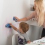 Mutter und Kind entfernen Flecken von Wand mit Histor Clean Wandfarbe Weiß seidenmatt.