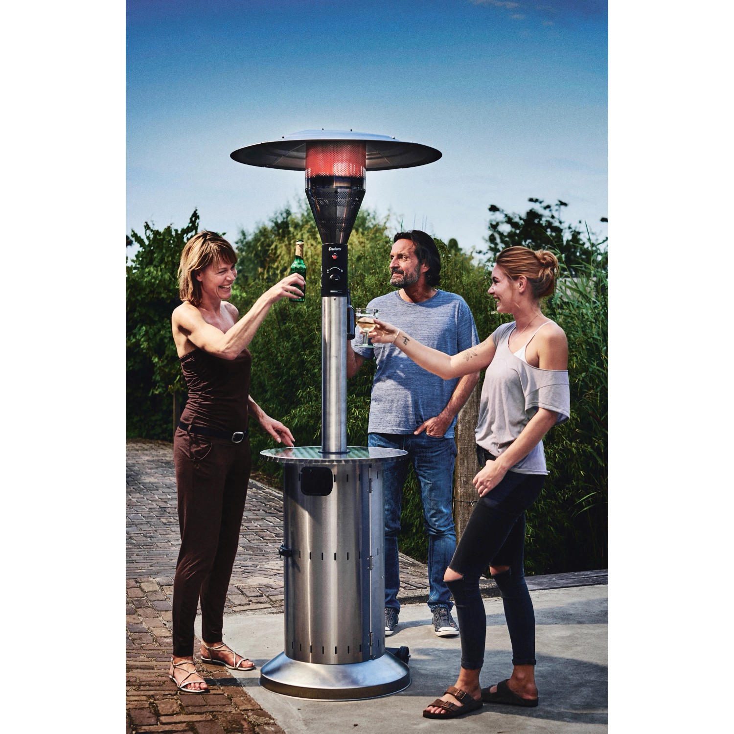 Enders Terrassenheizer Commercial mit Ablagetisch und drei Personen im Garten.