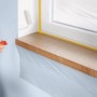 Anwendung der Tesa Abdeckfolie Easy Cover: Fensterbank und Fensterrahmen sind mit Folie und Klebeband geschützt.