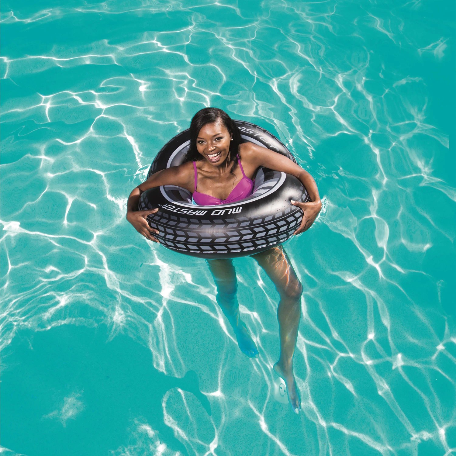 Frau im Wasser mit Bestway® Schwimmring Mud Master im Autoreifen-Design.
