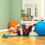 Frau macht Crunches mit blauem Gymnastikball und orangefarbenem Sitting Ball Hocker im Hintergrund.