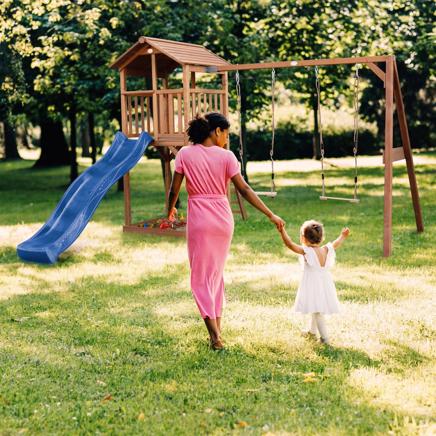 Axi Beach Tower Spielturm mit Doppelschaukel und blauer Rutsche im Garten.