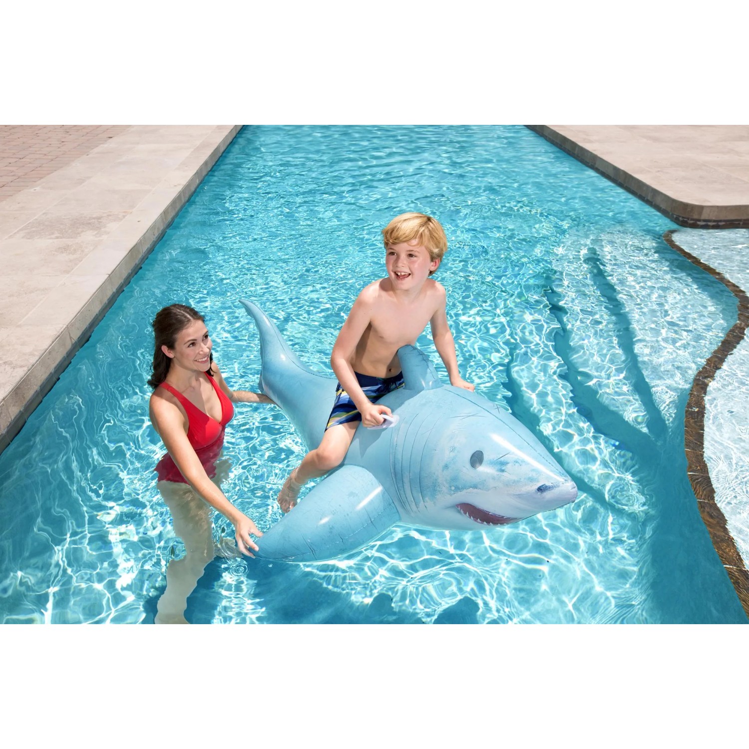 Kind auf blauem Bestway Schwimmtier Hai im Pool. Wasserspaß für Kinder.
