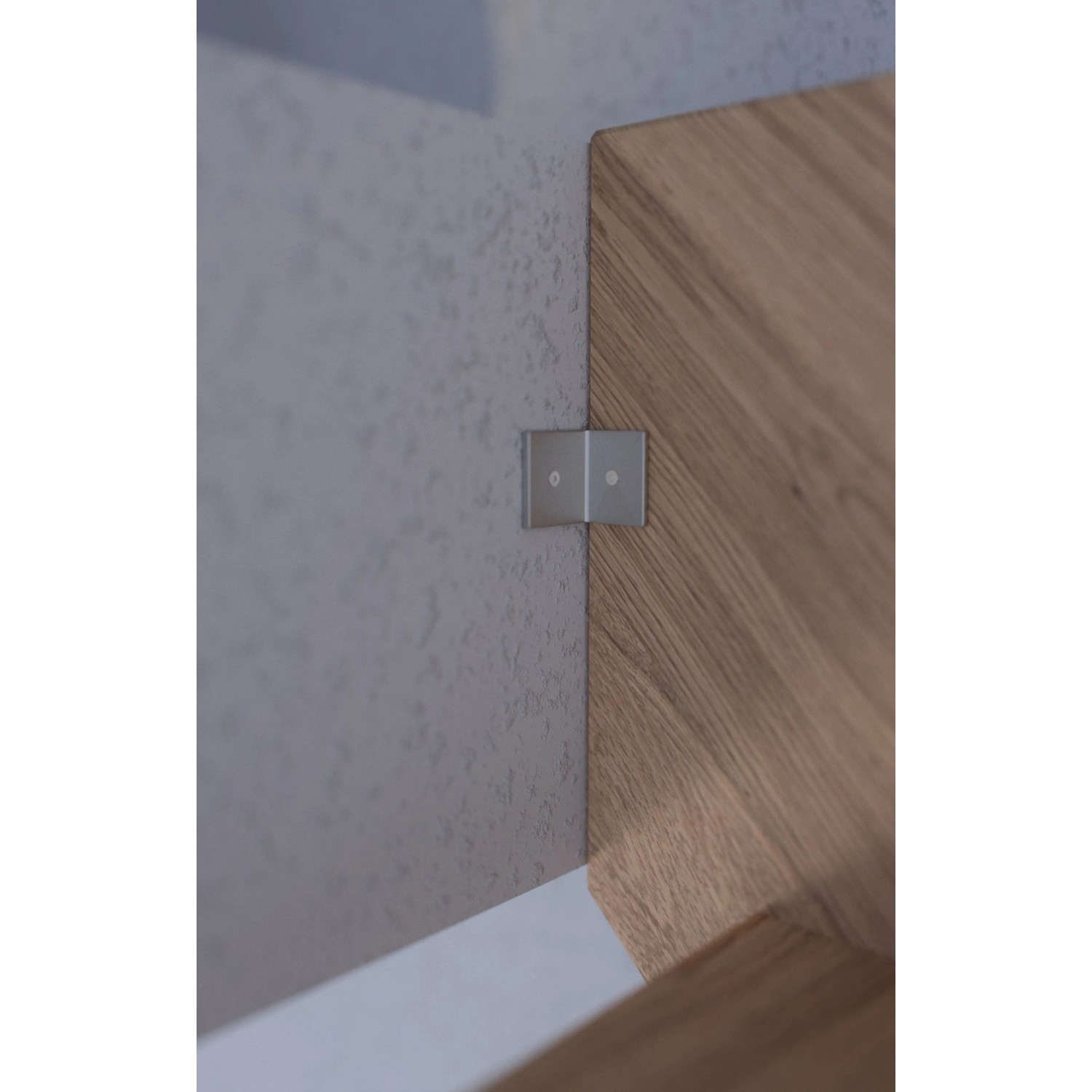 Detailaufnahme: StarWood Treppe Rhodos Eiche, gewendelt, mit Holz-Edelstahl-Geländer und Wandbefestigung.