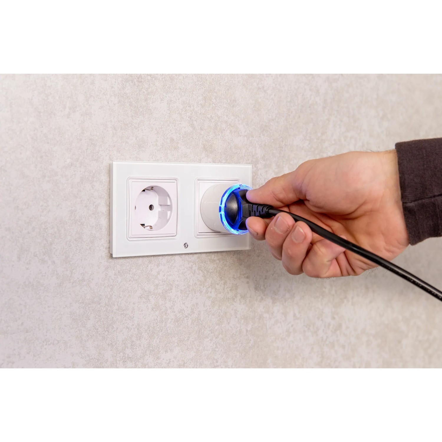 Shelly Smart-Stecker Plug S Gen3 Schwarz in Steckdose gesteckt, blaue LED leuchtet.