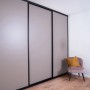 Raumhohe Schiebetür in Taupe mit schwarzem Profilrahmen. Ideal als Raumteiler oder für begehbare Schränke.
