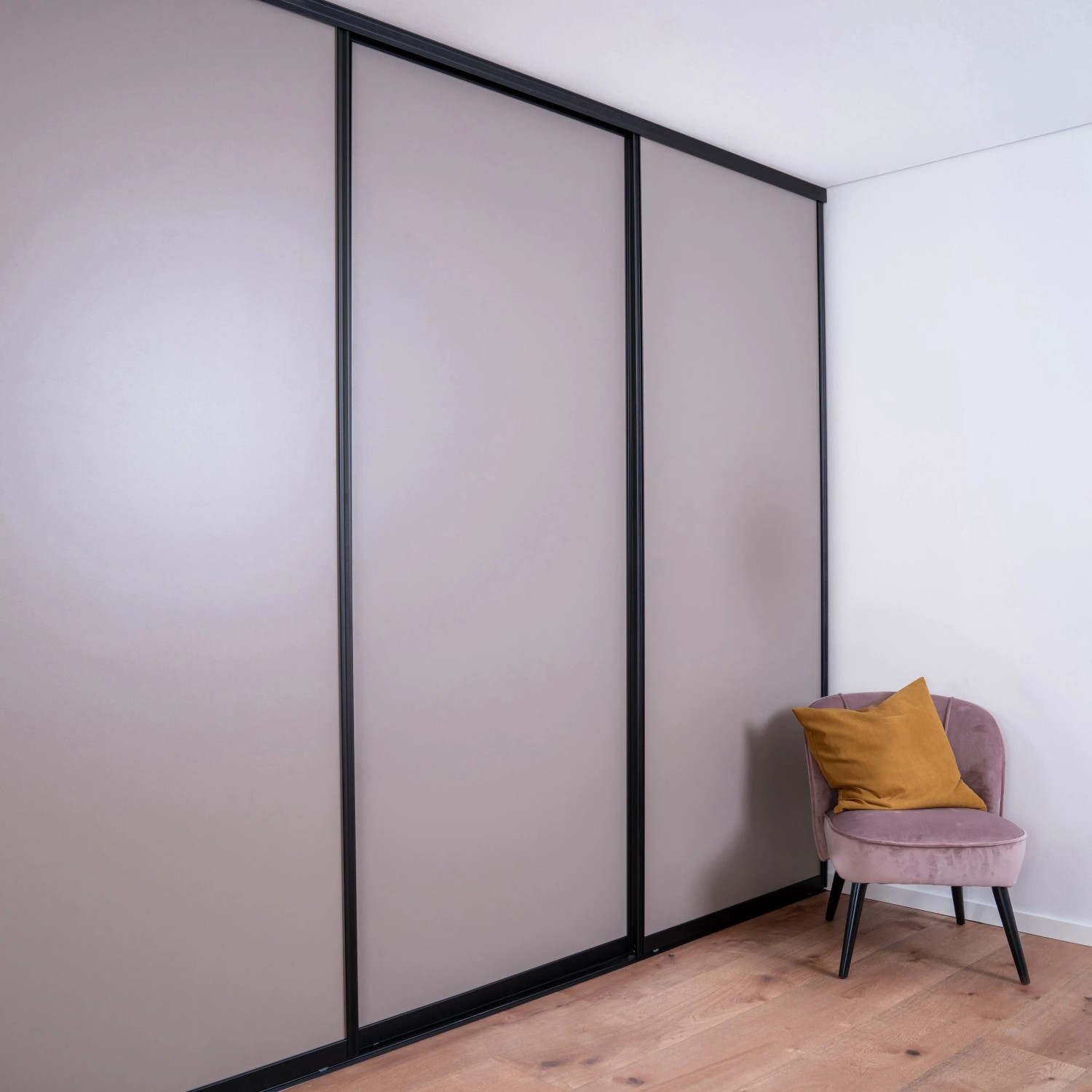 Raumhohe Schiebetür in Taupe mit schwarzem Profilrahmen. Ideal als Raumteiler oder für begehbare Schränke.