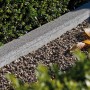 Grauer Minirandstein 50 cm als Beetbegrenzung im Garten.