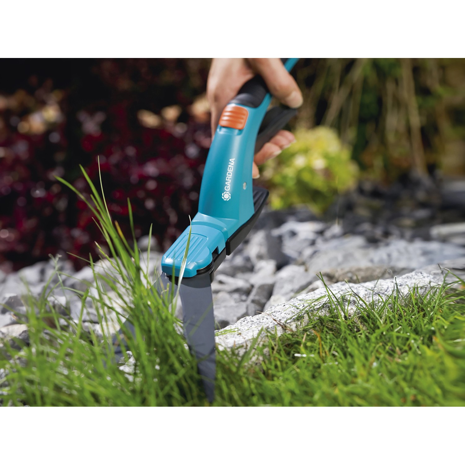 Gardena Comfort Grasschere in Aktion beim Rasenkantenschnitt. Ergonomischer Griff, präzise Klingen.