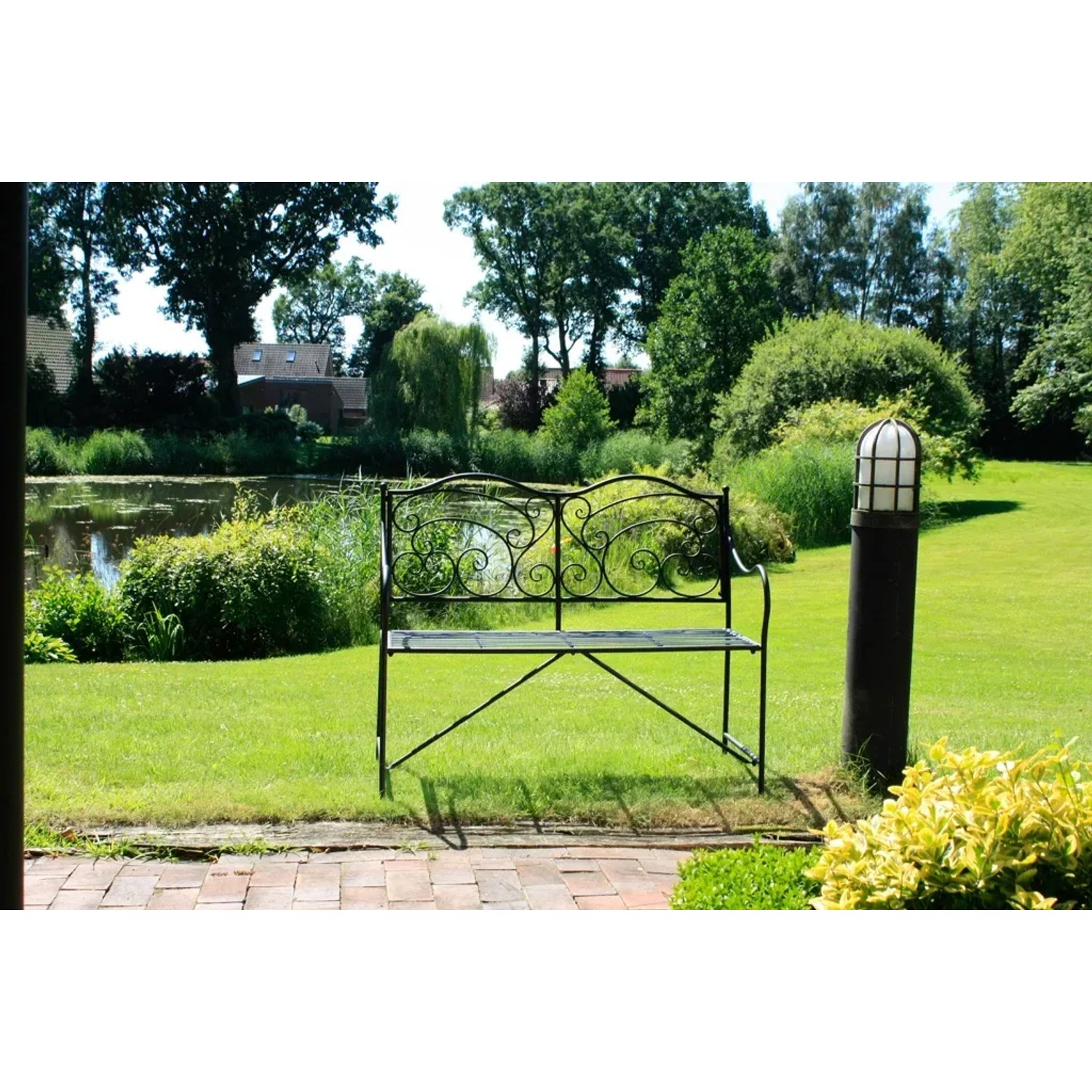 Mattschwarze Gartenbank Vesuv von Garden Pleasure, 111 cm breit, mit filigraner Rückenlehne im Grünen.