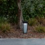Moderne Lutec LED Solar Wegeleuchte Dias, mattschwarz, neben einem Baum im Garten.