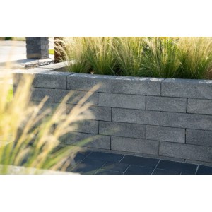 Graue Diephaus Palisade Limos Quarzit als Mauer mit gestrahlter Oberfläche, dahinter Ziergräser. Für Einfassungen.