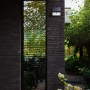 Schwarze Lutec LED Solar-Wandleuchte Tuda mit Bewegungsmelder außen an einer Hauswand.