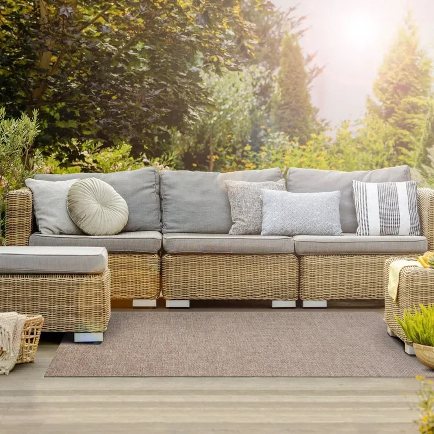 Wetterfester, brauner Outdoor Teppich Trani 90x400cm auf Terrasse vor Rattansitzgruppe.