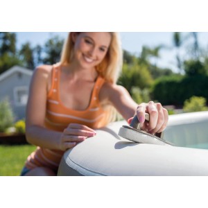 Frau reinigt Whirlpool mit Intex Reinigungs-Set, bestehend aus Bürste, Kescher und Schrubber.