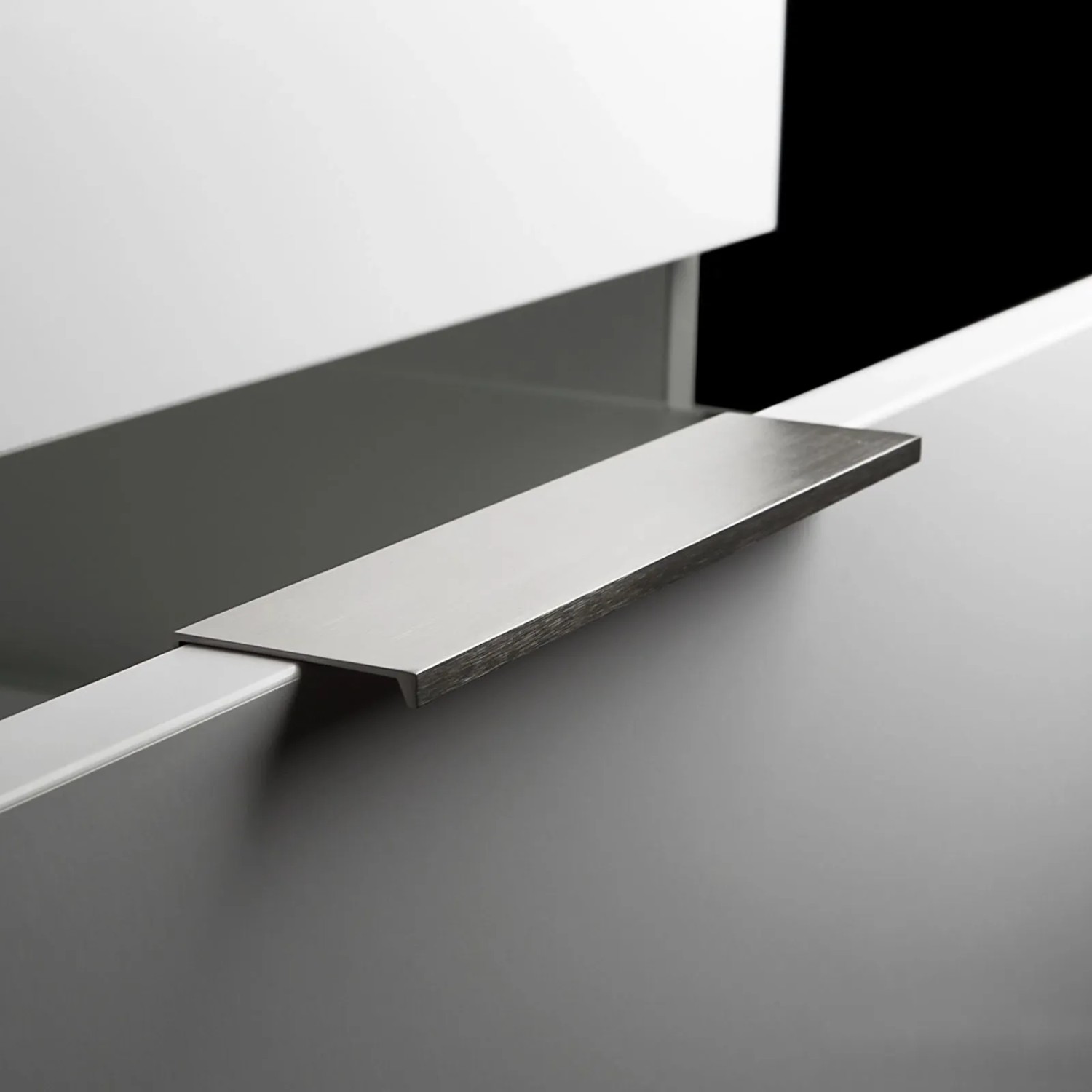 SOTECH Griffleiste Searl aus Aluminium in gebürsteter Edelstahloptik, als Profilgriff an einer hellgrauen Möbelfront.