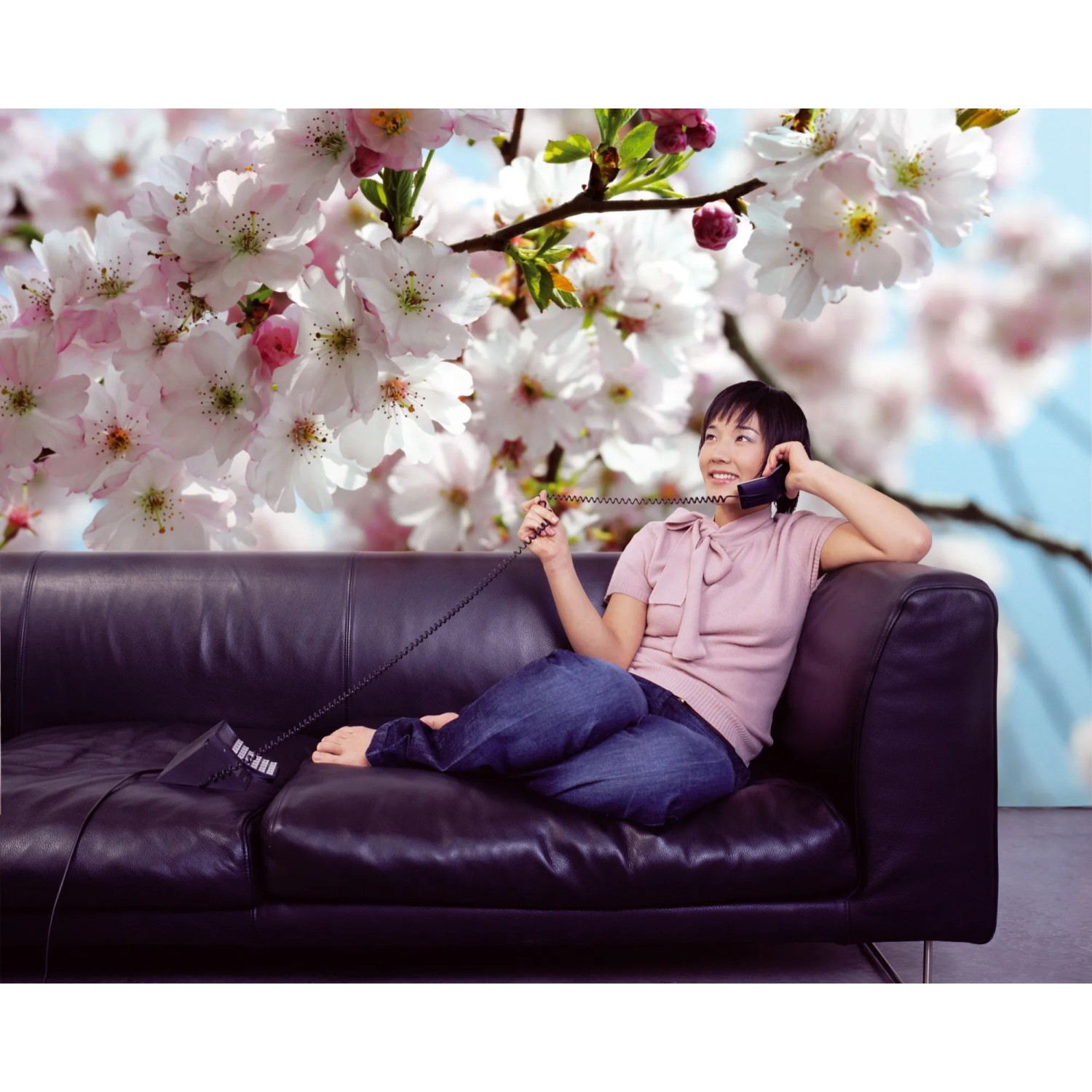 Komar Fototapete Spring mit Frau auf Sofa vor blühenden Kirschbaum, 368x254 cm.