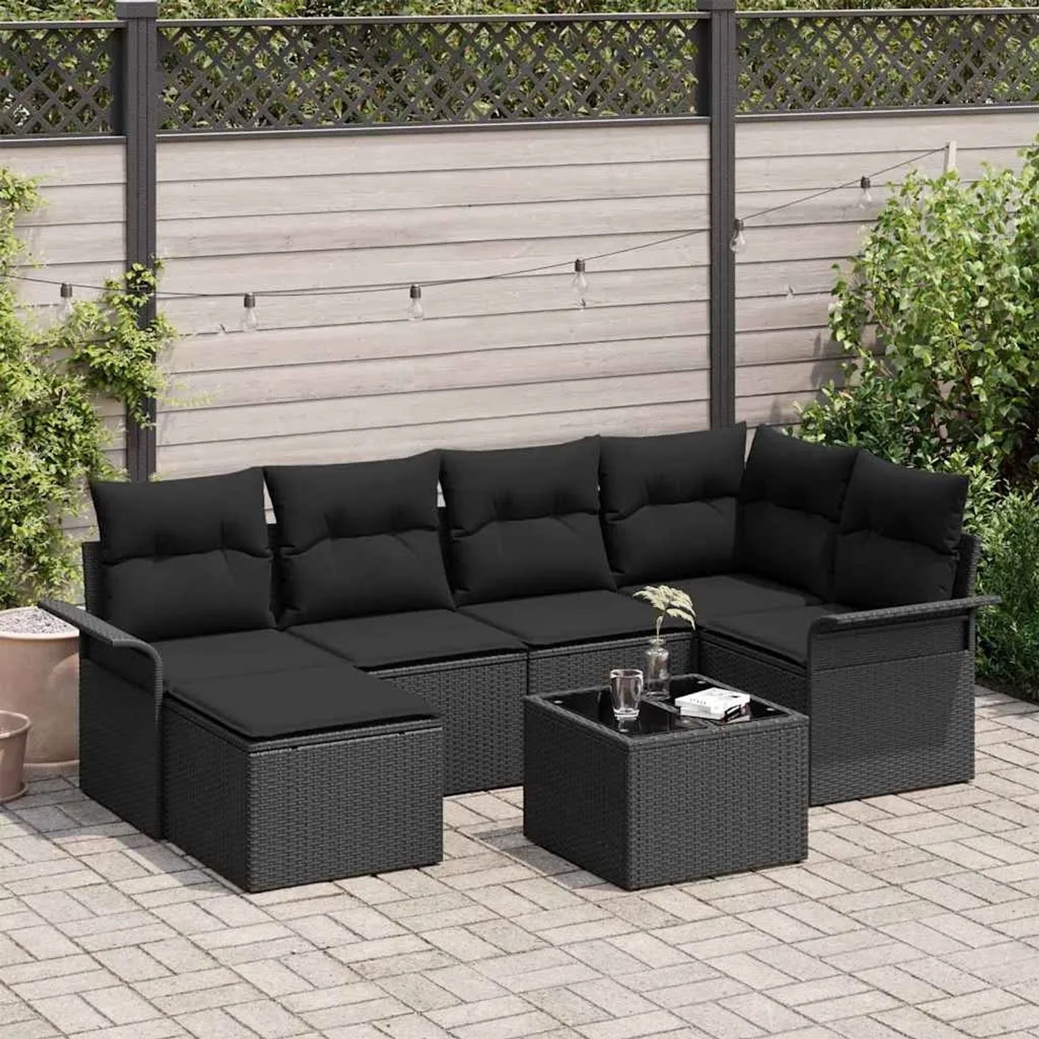 Schwarzes 7-teiliges vidaXL Garten-Sofa-Set aus Poly Rattan mit Tisch und Kissen.
