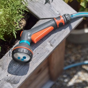 Gardena Multifunktionsbrause Classic auf Holzkiste, Gartenspritze mit verschiedenen Sprühbildern.