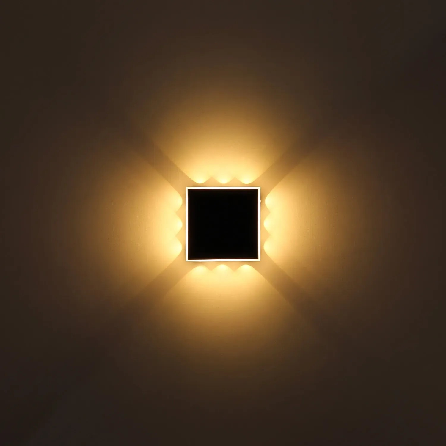 Quadratische, schwarze LED-Wandleuchte Saidy (22x22 cm) mit warmweissem Licht.