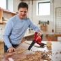 Mann benutzt Einhell Akku-Bläser TE-CB 18/180 Li-Solo zum Säubern einer Werkbank von Holzspänen.
