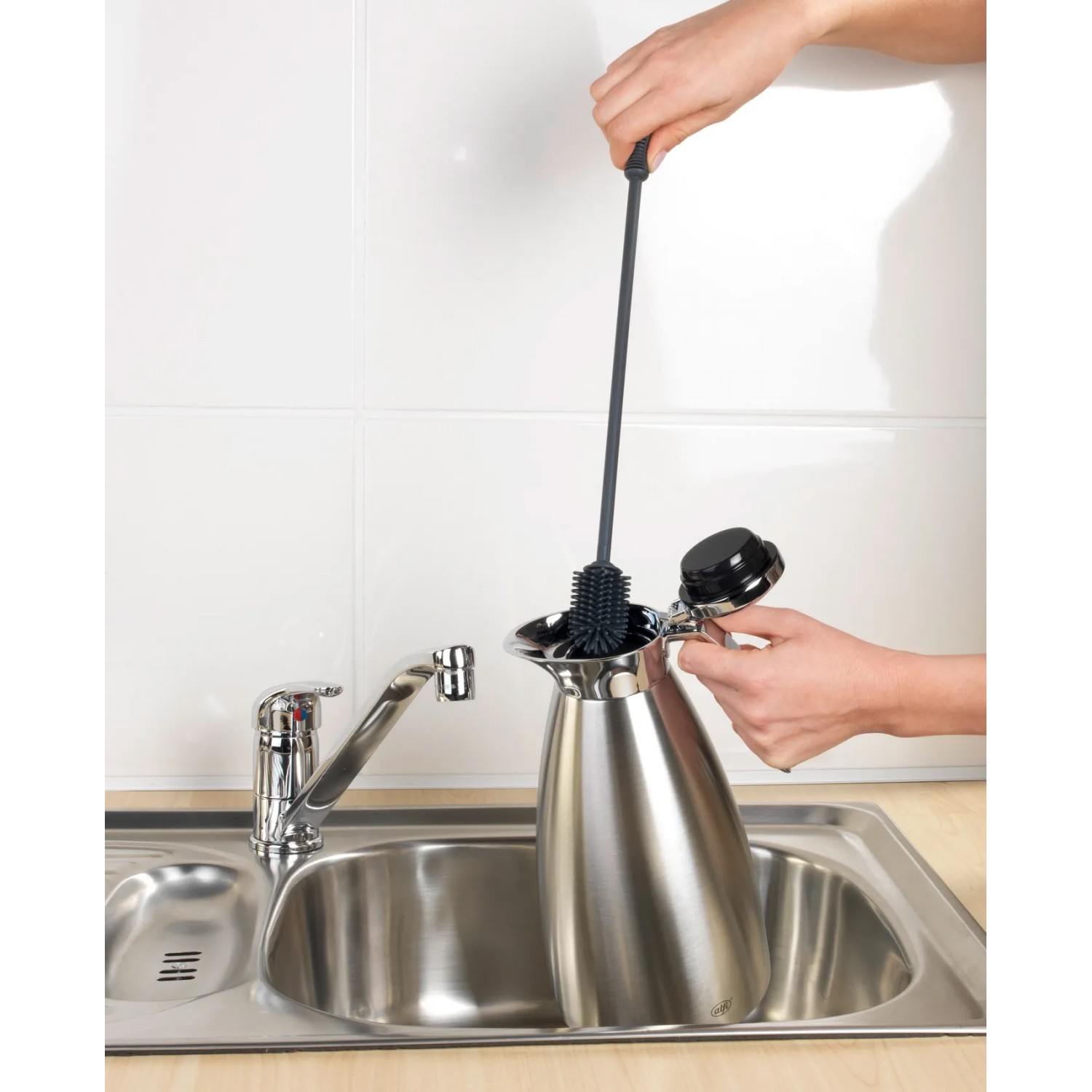 Anthrazitfarbene Wenko Silikon Flaschenbürste (38 cm) reinigt eine Thermoskanne in der Spüle.
